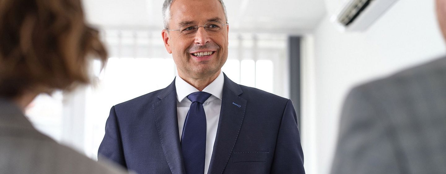 drei Personen im Business-Look stehend im Gespräch  | Wirtschaftsprüfung Essen | Wirtschaftsprüfung Münster | Wirtschaftsprüfung Bochum | Märkische Revision GmbH
